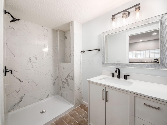 bathroom with wood tiled floor, vanity, and a marble finish shower