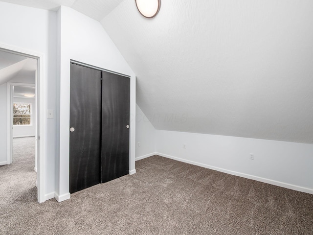 additional living space with lofted ceiling, carpet flooring, and baseboards