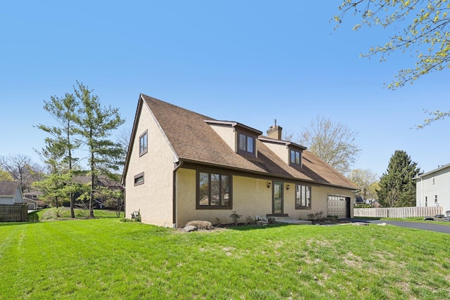 view of front of house with aphalt driveway, fence, stucco siding, a front yard, and a garage