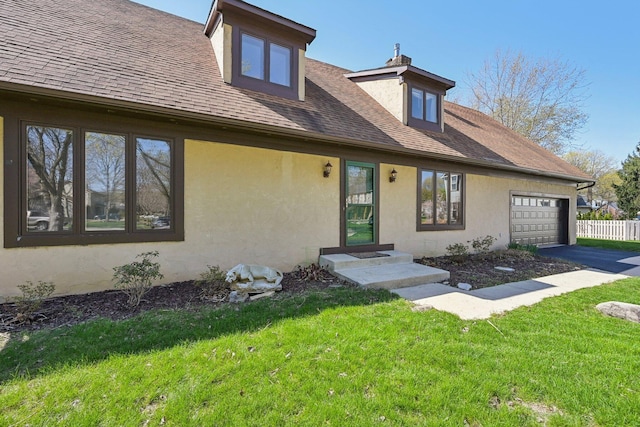 view of front facade featuring fence, a front lawn, stucco siding, an attached garage, and roof with shingles