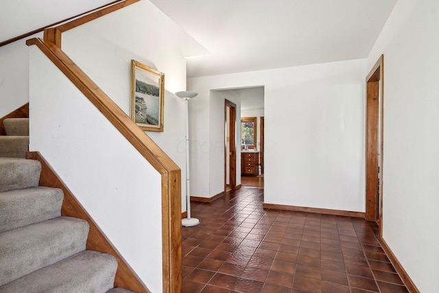 stairs featuring tile patterned floors and baseboards