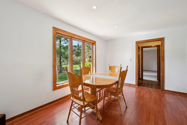 dining room featuring baseboards, wood finished floors, and recessed lighting