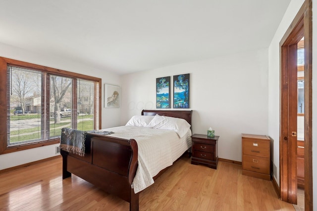 bedroom featuring light wood finished floors and baseboards