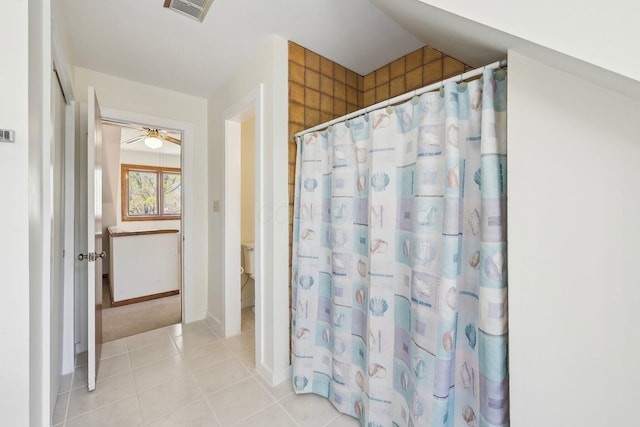 bathroom with tile patterned floors, visible vents, toilet, baseboards, and a shower with shower curtain