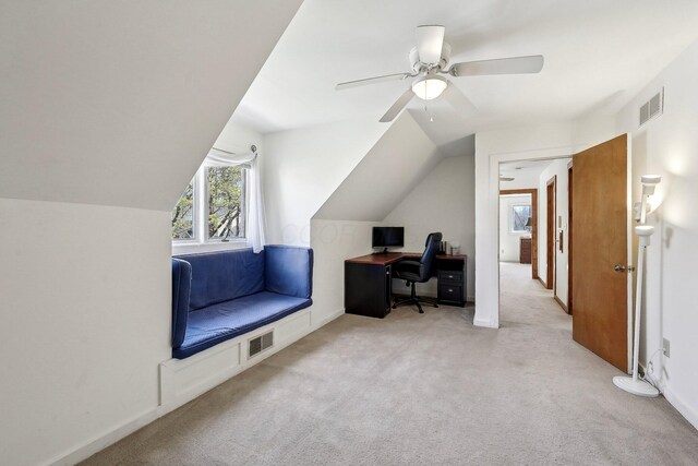 carpeted office space featuring vaulted ceiling, visible vents, and a ceiling fan