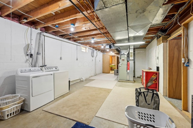 unfinished basement with heating unit and washer and clothes dryer