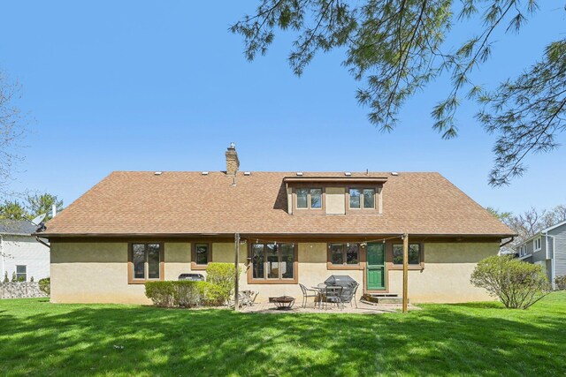 back of property featuring a yard and stucco siding