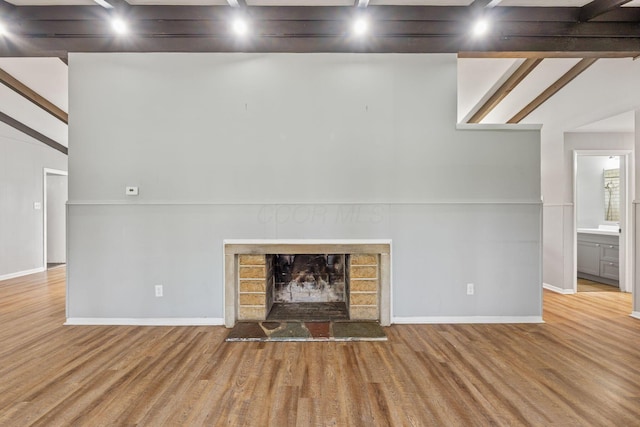 3434 Fishinger Rd, Columbus, OH 43221 - unfurnished living room with baseboards, wood finished floors, and a fireplace with raised hearth