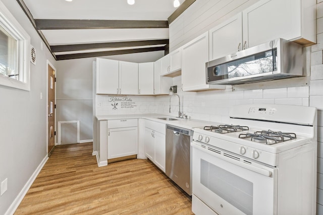 3434 Fishinger Rd, Columbus, OH 43221 - kitchen featuring a sink, white cabinetry, beamed ceiling, backsplash, and appliances with stainless steel finishes