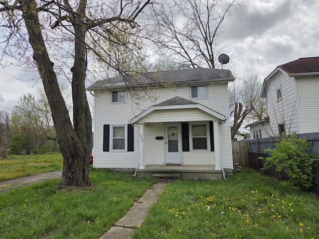 view of front of property featuring a porch, fence, and a front yard
