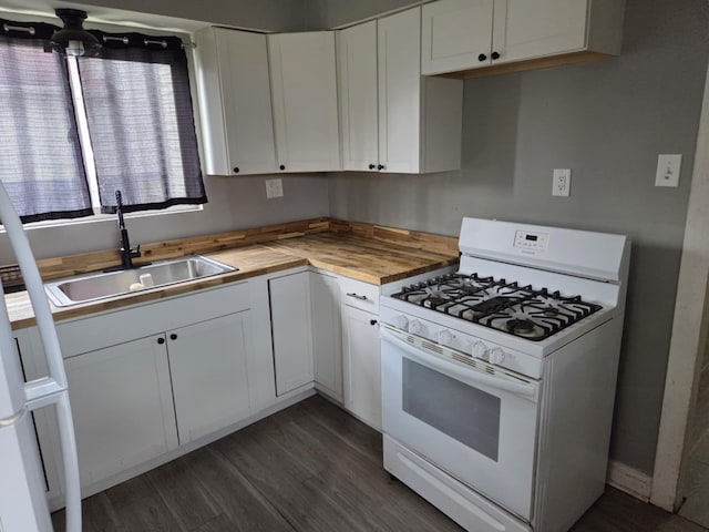 kitchen with dark wood-style flooring, gas range gas stove, a sink, white cabinets, and wood counters