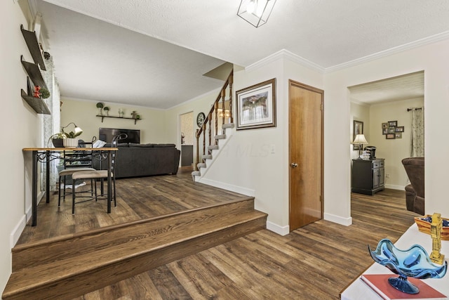 interior space featuring baseboards, wood finished floors, stairs, and ornamental molding