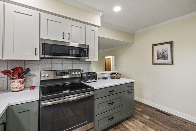 kitchen featuring crown molding, decorative backsplash, visible vents, appliances with stainless steel finishes, and dark wood-style floors