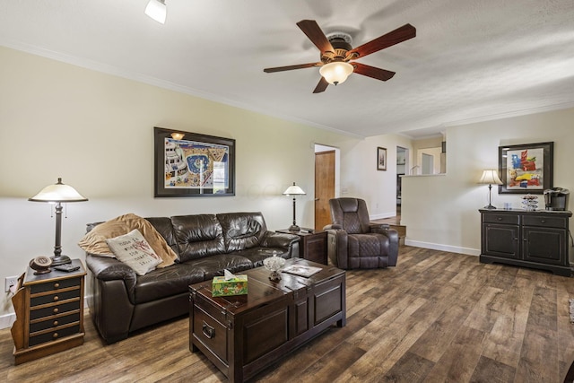 living room featuring baseboards, a ceiling fan, crown molding, and dark wood-style floors
