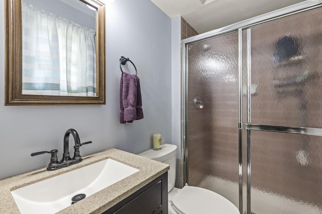 full bathroom with toilet, vanity, and a stall shower
