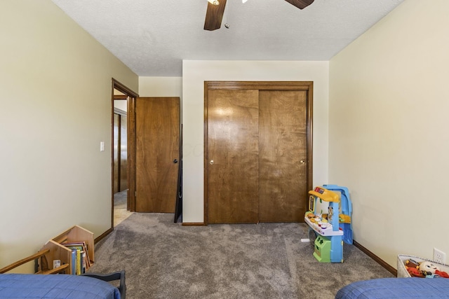 carpeted bedroom featuring baseboards, a closet, and ceiling fan