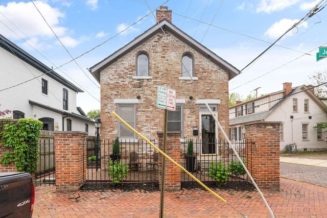 129 Jackson St, Columbus, OH 43206 - view of front of home with brick siding, a chimney, and fence