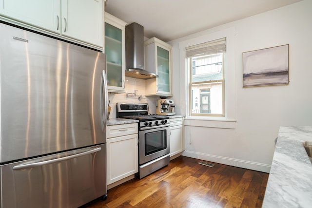 129 Jackson St, Columbus, OH 43206 - kitchen featuring stainless steel appliances, wall chimney exhaust hood, dark wood-style flooring, baseboards, and white cabinetry