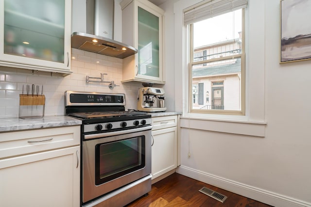 129 Jackson St, Columbus, OH 43206 - kitchen with gas stove, range hood, baseboards, and backsplash