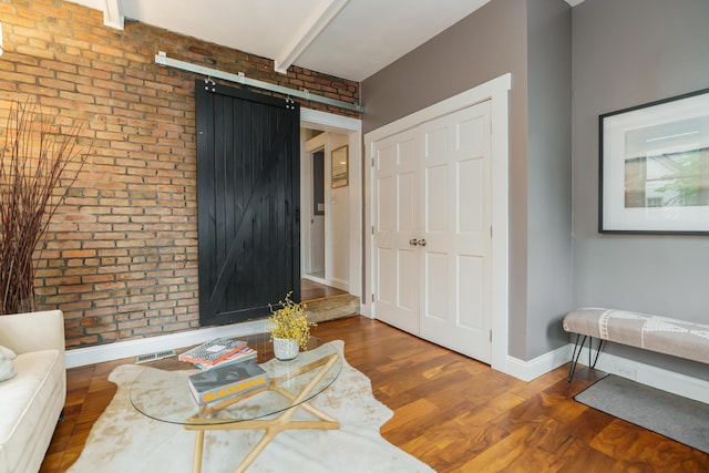 129 Jackson St, Columbus, OH 43206 - living area featuring brick wall, wood finished floors, a barn door, baseboards, and beamed ceiling