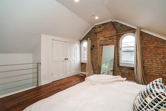 129 Jackson St, Columbus, OH 43206 - bedroom with wood finished floors, brick wall, lofted ceiling, and a closet
