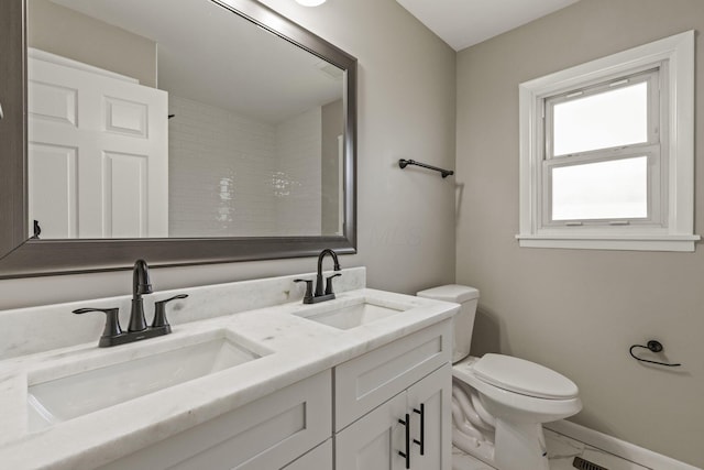 full bathroom with marble finish floor, toilet, a sink, and baseboards