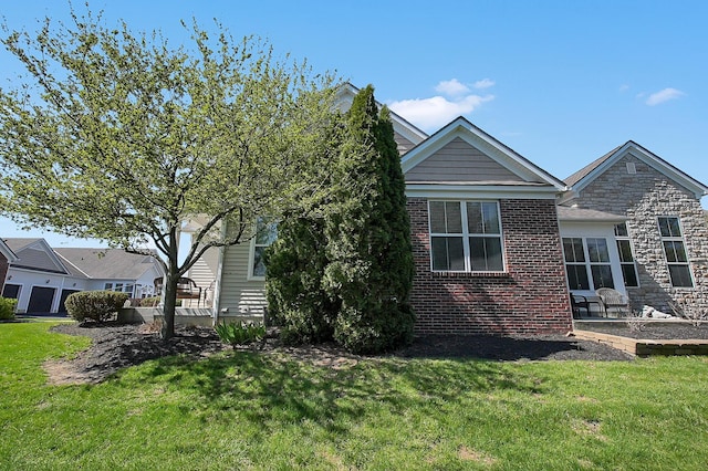 exterior space featuring brick siding, a yard, and stone siding