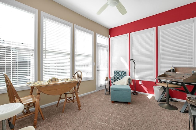 carpeted office space featuring a ceiling fan and baseboards