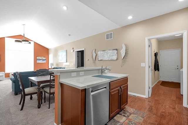 kitchen with stainless steel dishwasher, open floor plan, visible vents, brown cabinetry, and light countertops