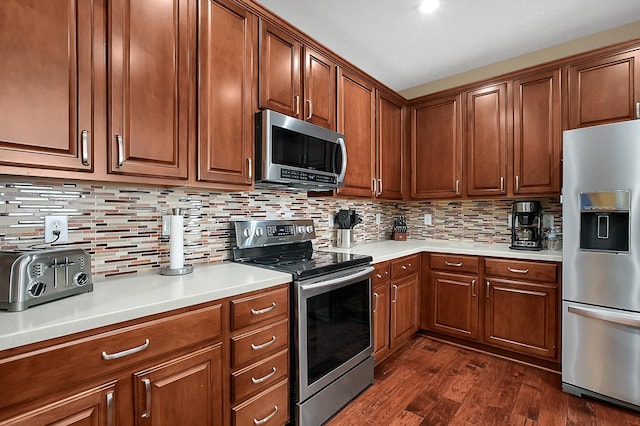 kitchen with backsplash, dark wood-style flooring, appliances with stainless steel finishes, and light countertops