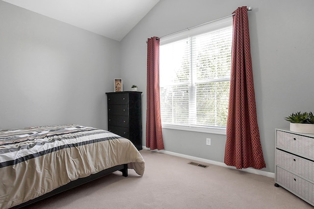 bedroom with visible vents, vaulted ceiling, baseboards, and light colored carpet