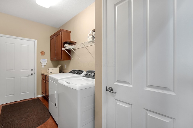 washroom featuring cabinet space, dark wood-type flooring, and separate washer and dryer