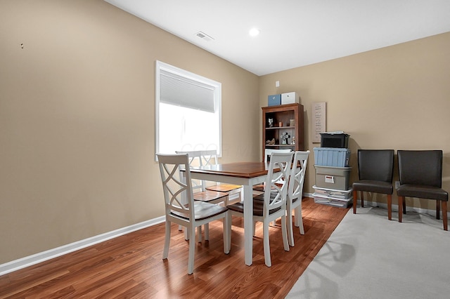 dining space featuring baseboards, wood finished floors, visible vents, and recessed lighting