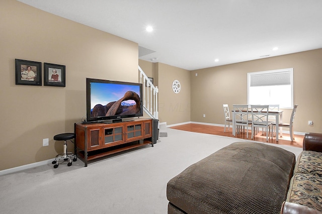carpeted living room with recessed lighting, baseboards, and stairs