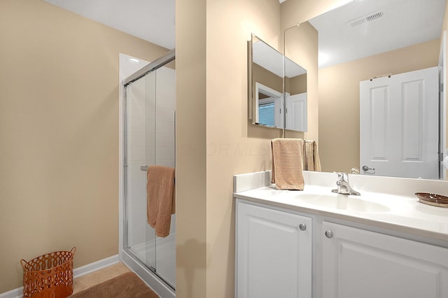 bathroom featuring vanity, visible vents, and a shower stall