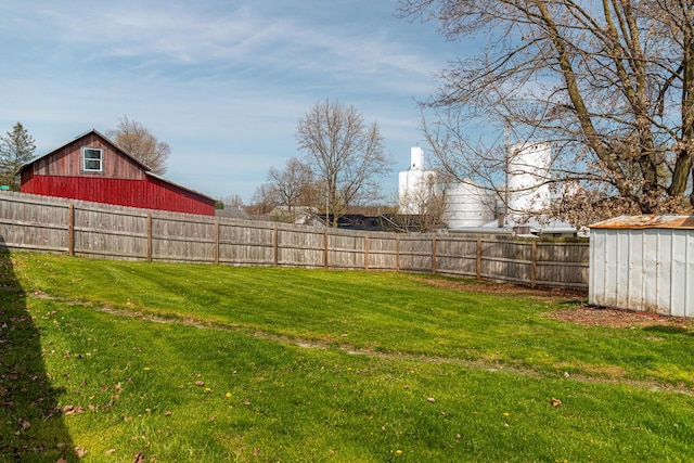 view of yard featuring a fenced backyard, an outbuilding, and a storage shed