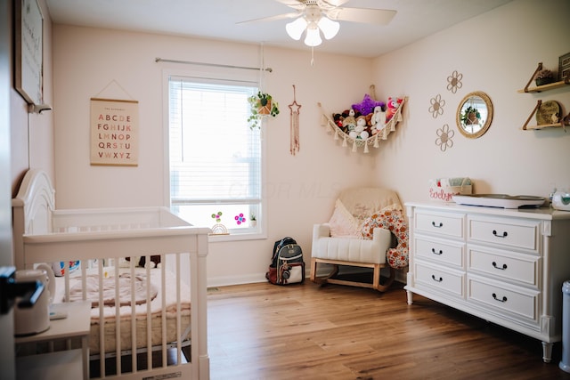 17920 Miller Rd, Richwood, OH 43344 - bedroom featuring a nursery area, baseboards, wood finished floors, and ceiling fan