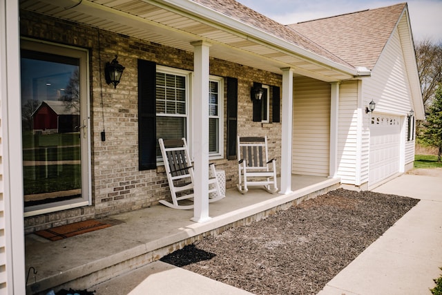 17920 Miller Rd, Richwood, OH 43344 - doorway to property with concrete driveway, brick siding, a shingled roof, and covered porch