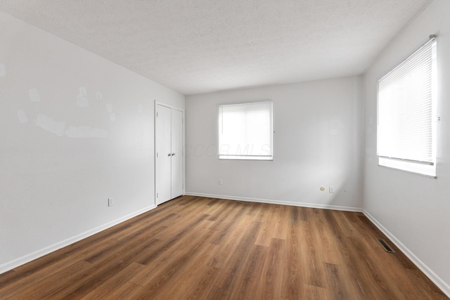 3318 Darbyshire Dr, Hilliard, OH 43026 - empty room with visible vents, baseboards, wood finished floors, and a textured ceiling