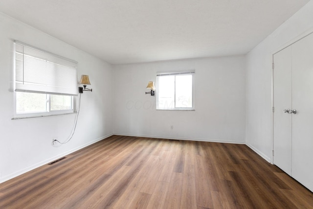 3318 Darbyshire Dr, Hilliard, OH 43026 - unfurnished bedroom with baseboards, wood finished floors, and multiple windows