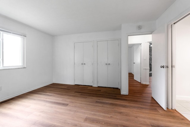 3318 Darbyshire Dr, Hilliard, OH 43026 - unfurnished bedroom featuring two closets, baseboards, and wood finished floors
