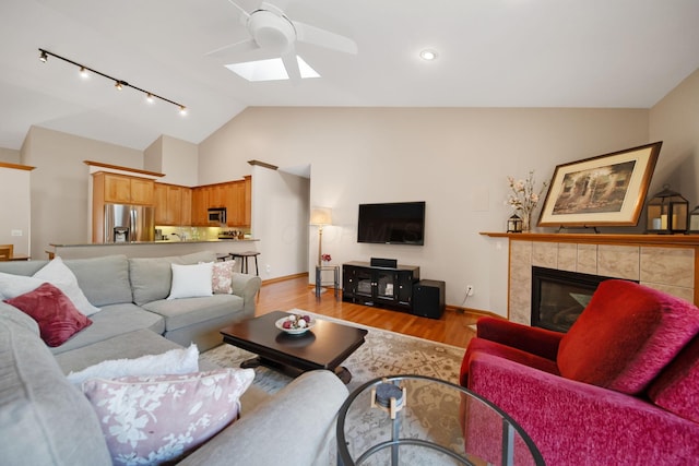 2882 Kool Air Way, Columbus, OH 43231 - living area with a ceiling fan, a skylight, light wood finished floors, a tiled fireplace, and rail lighting