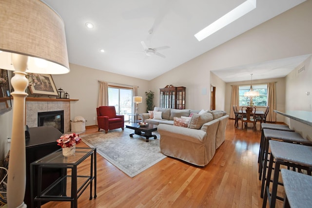 2882 Kool Air Way, Columbus, OH 43231 - living area with high vaulted ceiling, a ceiling fan, light wood finished floors, a fireplace, and visible vents