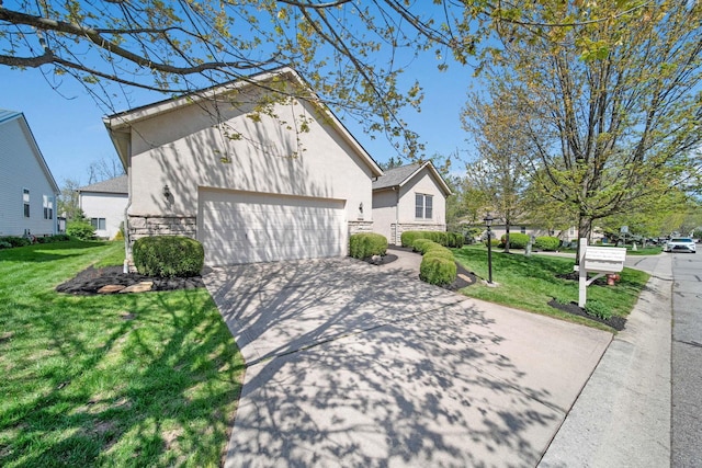 2882 Kool Air Way, Columbus, OH 43231 - view of property exterior featuring stone siding, a yard, a garage, and stucco siding
