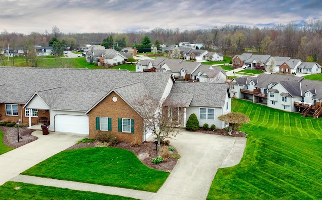 ranch-style house featuring brick siding, a residential view, driveway, and a garage