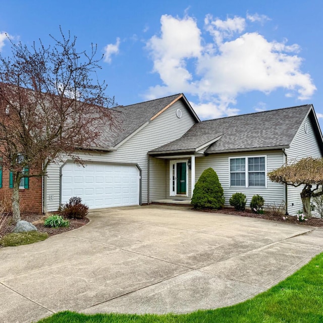 ranch-style house featuring a garage, driveway, and roof with shingles