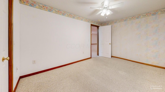 carpeted empty room featuring baseboards and ceiling fan