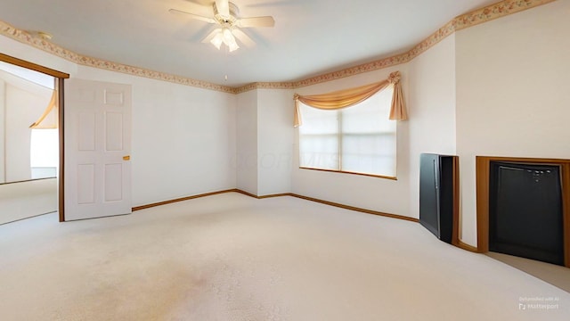 interior space with carpet floors, baseboards, and ceiling fan