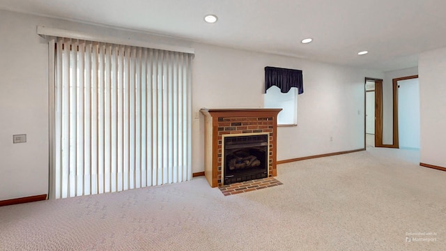 unfurnished living room featuring recessed lighting, baseboards, carpet floors, and a fireplace