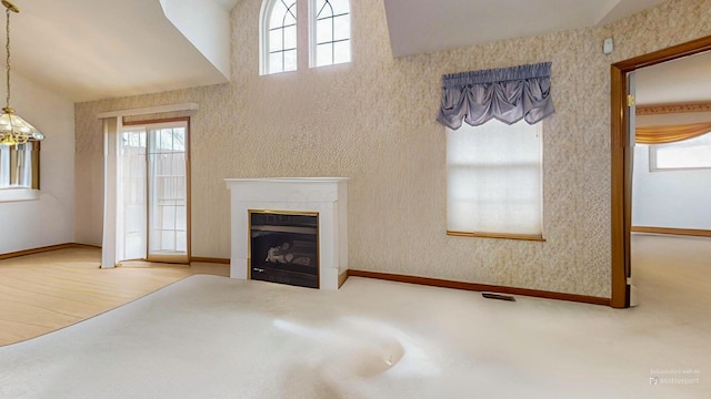 unfurnished living room featuring baseboards, vaulted ceiling, visible vents, and a fireplace